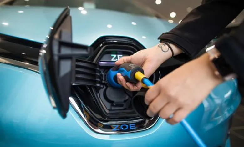 Person plugging in an electric vehicle charger.